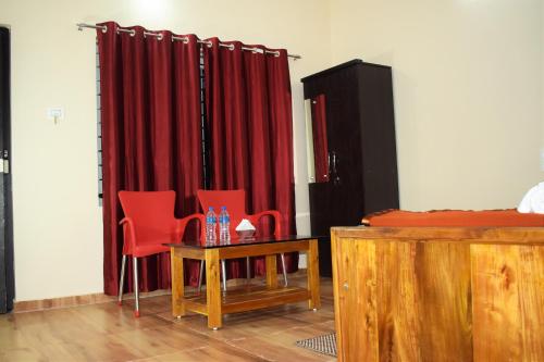 戈卡尔纳Viraz Valley的一间设有红色窗帘和桌椅的房间