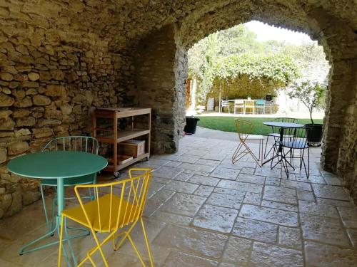 SalettesLe Mas Bellane的石头墙内带桌椅的庭院