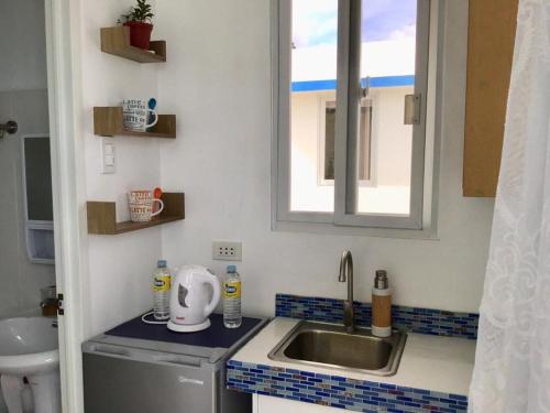 杜马格特1888 Beach Resort的一个带水槽和窗户的小厨房