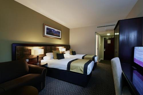 伦敦千禧国际切尔西足球俱乐部国敦酒店的配有一张床和一台平面电视的酒店客房