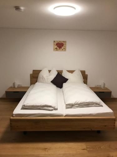 万丹斯Murmenta Appartements的一间卧室配有带白色床单和枕头的床。