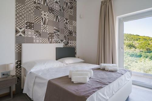 SerramezzanaCilento Victory House的一间卧室配有一张带两条白色毛巾的床