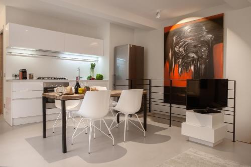 贝加莫拉考特维奇亚公寓的厨房配有桌椅和电视。