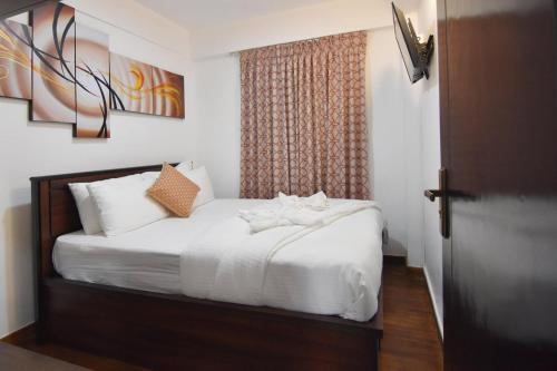 努沃勒埃利耶水手小屋美景公寓的一间卧室配有一张带白色床单的床和一扇窗户。