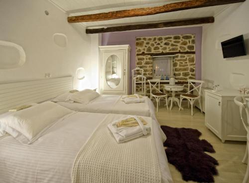 卡斯托里亚奥罗洛格普洛斯庄园豪华酒店的一间带两张床的大卧室和用餐室