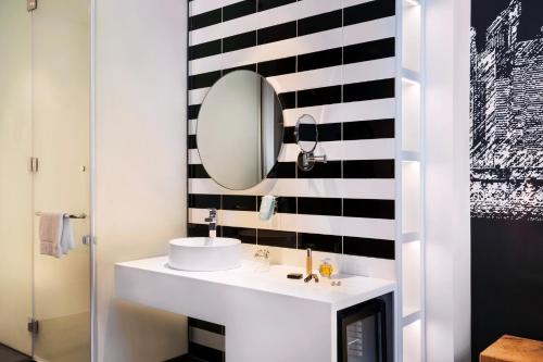 迪拜宜必思尚品迪拜机场酒店的浴室设有白色水槽和镜子