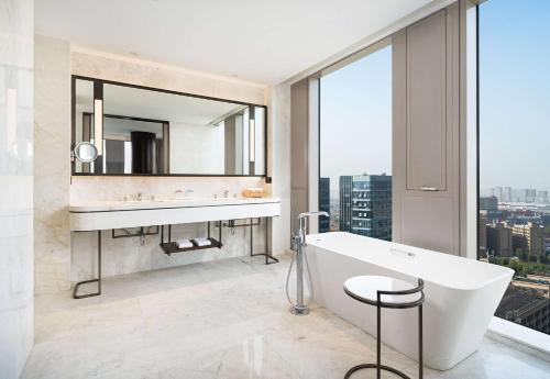 杭州杭州新天地丽笙酒店的带浴缸、水槽和镜子的浴室