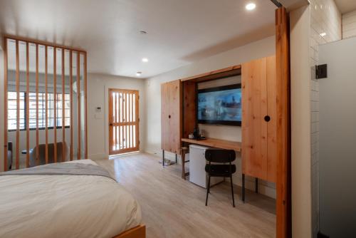 卡纳布Best Friends Roadhouse and Mercantile的一间卧室配有一张床、一张书桌和一台电视。