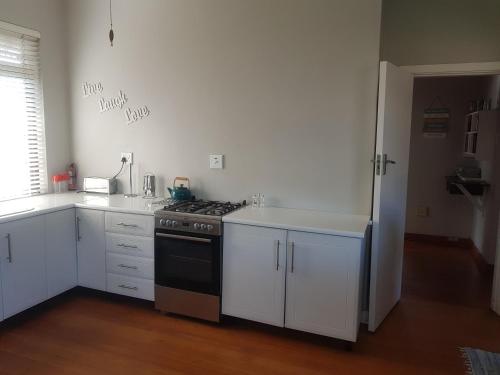 乌姆科马斯Turtle Creek - Leatherback的厨房配有白色橱柜和炉灶烤箱。