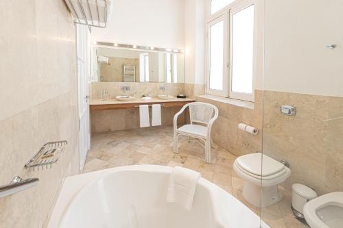 布宜诺斯艾利斯Cassa Lepage Art Hotel Buenos Aires的带浴缸、卫生间和盥洗盆的浴室