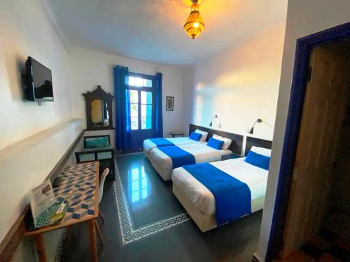 卡萨布兰卡中心酒店的一间卧室设有两张床、一张桌子和一个窗口