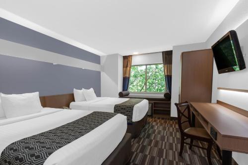 林夕昆高地温德姆BWI机场麦克罗特尔酒店套房的酒店客房配有两张床和一张书桌