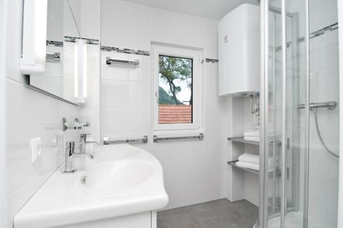 赛特朵夫苏泽恩霍夫酒店的白色的浴室设有水槽和淋浴。