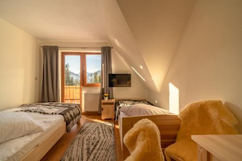 考斯赛力克Willa Na Polanie的一间卧室设有两张床、一把椅子和一个窗户。