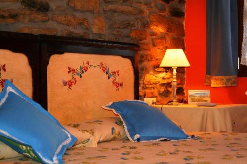 德巴佩拉库阿萨卡农家乐的一张带蓝色枕头的床和一张带台灯的桌子