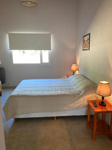 埃尔卡拉法特Hotel y Cabañas Las Marías的一间卧室配有一张大床、两盏灯和两张桌子