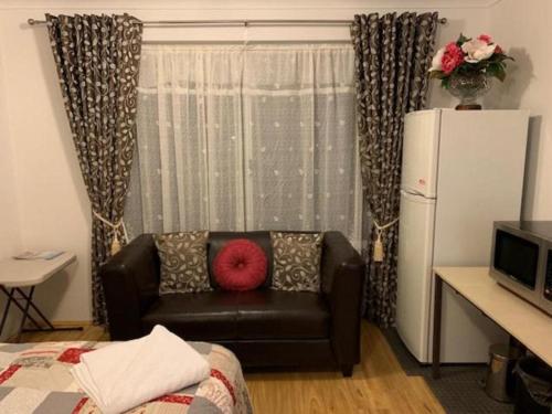 珀斯Ascot Comfort的带沙发和红色枕头的客厅