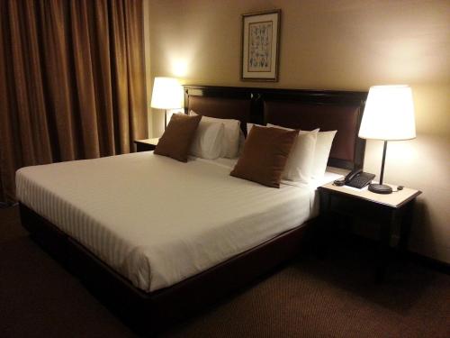 马六甲蜜梦酒店的酒店客房设有一张大床和两盏灯