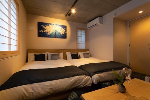 东京Sakura Stay Otorii的卧室配有两张床,墙上挂着一幅画
