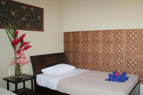 维拉港City Lodge的一间卧室设有两张床和花瓶