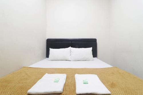 SukodonoHotel Omah Ampel Syariah的床上有两条白色毛巾