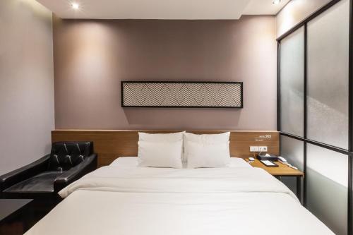 釜山Beomil Brown Dot Hotel的配有一张床和一把椅子的酒店客房