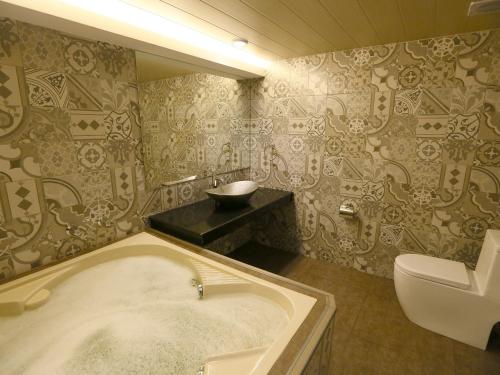 马尼拉Hotel Ava Malate的带浴缸和卫生间的浴室。