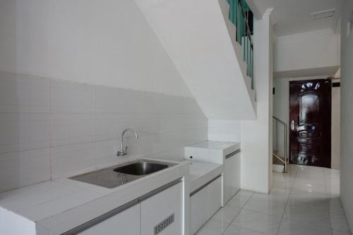 三宝垄RedDoorz Hostel near Kota Lama Semarang的白色的厨房设有水槽和走廊