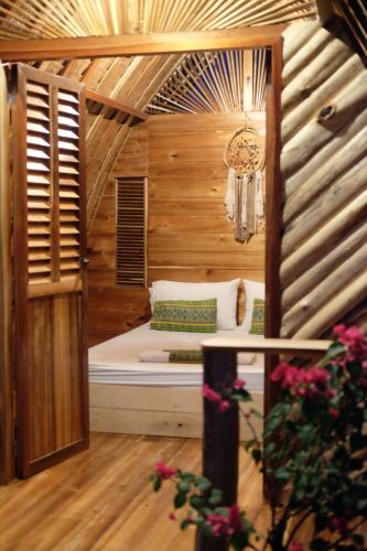 圣维森特Palayan Paradise Huts的一间小卧室,配有一张位于木制房间内的床