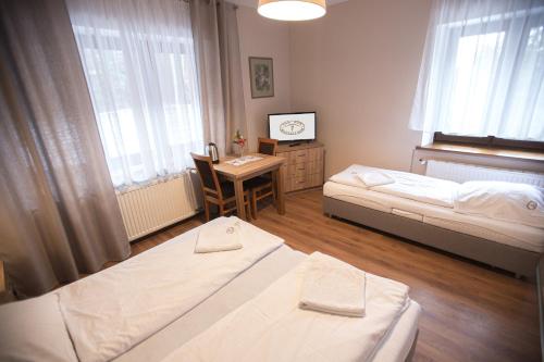 米迪格兹多姆纳沃杜思巴登旅馆的一间卧室配有两张床、一张桌子和一张书桌