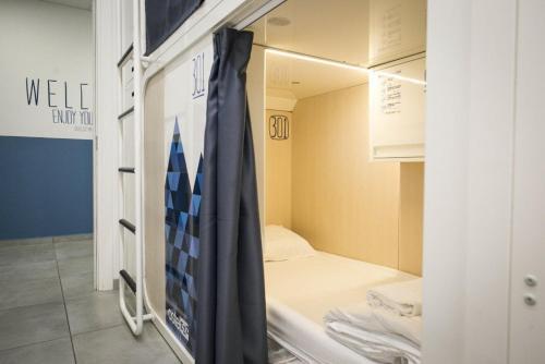 米兰Ostelzzz Milano的小房间设有一张床和一个衣柜