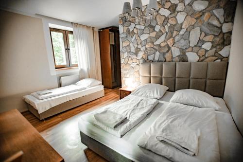 米迪格兹多姆纳沃杜思巴登旅馆的一间卧室设有两张床和石墙
