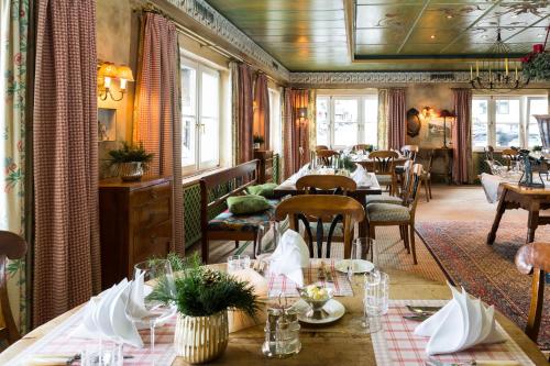 祖尔斯雪绒花酒店的用餐室设有桌椅和窗户。