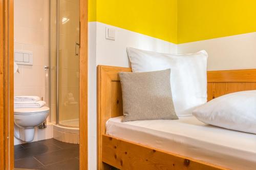 斯图加特Centro Hotel Sautter的一间卧室设有一张带淋浴和卫生间的床。
