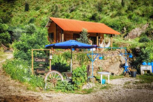 菲盖罗杜什维纽什Unique Tiny House with Natural Building Techniques的一座房子,上面有一把伞和一个标志