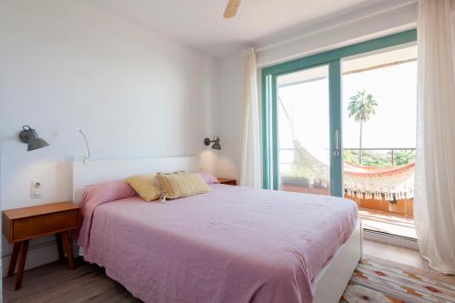 加瓦Gavamar Castelldefels Beachfront Apartment- Direct access to the beach的一间卧室设有一张床和一个大窗户