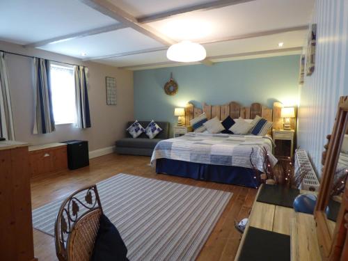 梅布尔索普The Cross Guest House的一间卧室配有一张大床和一张沙发