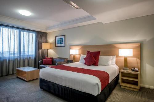 班伯里Bunbury Hotel Koombana Bay的酒店客房设有一张大床和一张沙发。
