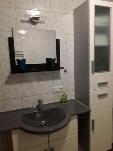 基希海姆Ferienwohnung Mayer的一间带水槽和镜子的浴室