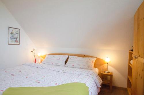 米德尔哈根Ferienwohnung Stockrose的卧室配有白色的床和2个枕头