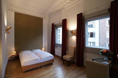 杜塞尔多夫斯特恩酒店的一间卧室设有一张床和一个大窗户