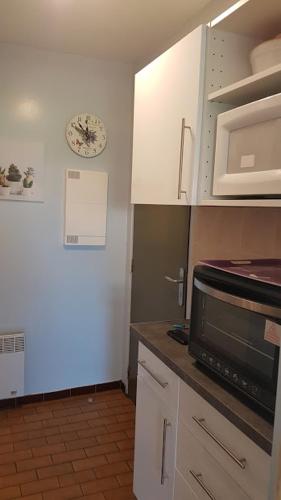圣保罗莱达Appartement T1 central pour cures courts séjours的厨房配有白色橱柜和微波炉