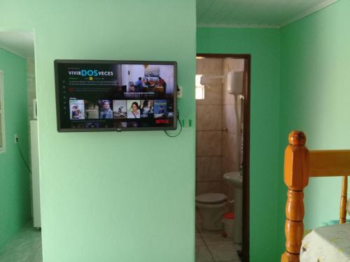 圣加布里埃尔Pousada Cabral的浴室墙上挂着电视