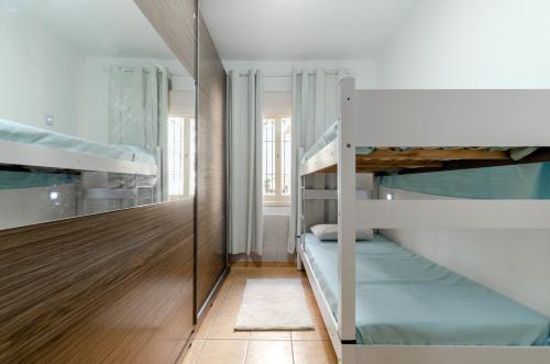 卡诺阿斯casa das flores的客房设有两张双层床和镜子