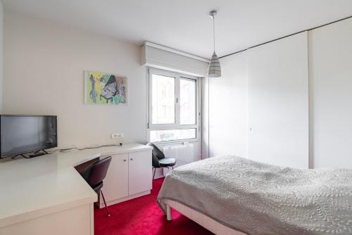 斯特拉斯堡Strasbourg - Cosy Contades的一间卧室配有一张床、一张书桌和一台电视。