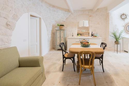 阿尔贝罗贝洛Trulli Resort Aia Piccola的厨房以及带桌椅的用餐室。