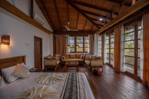 达瓦拉维Jungle Paradise的带沙发的大客厅和带窗户的客厅