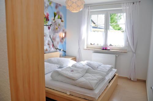 马林费尔德Ferienhaus Müritzsonne / EG-Appartement的窗户客房内的一张床位