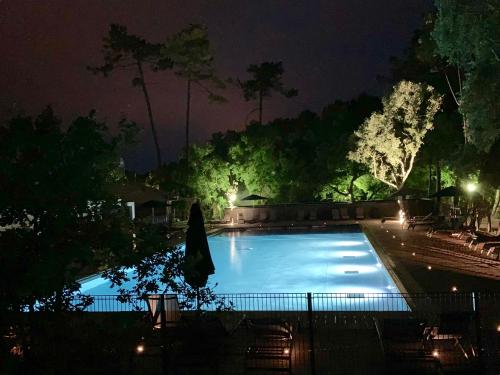 翁德尔Green Resort的夜间游泳池,配有遮阳伞和椅子