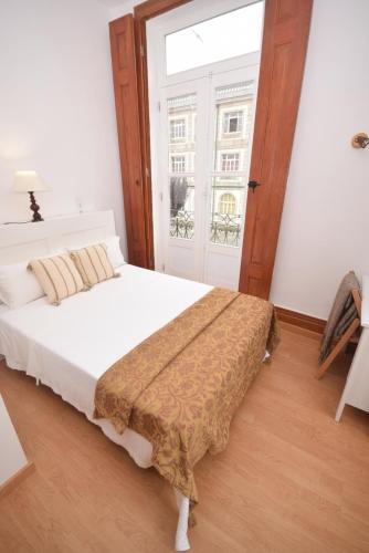 图伊Pension La Corredera的一间卧室设有一张床和一个大窗户